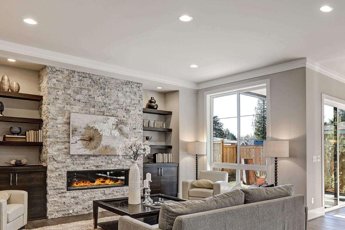 Living room with recessed lighting, fireplace, large windows and neutral contemporary furnishings