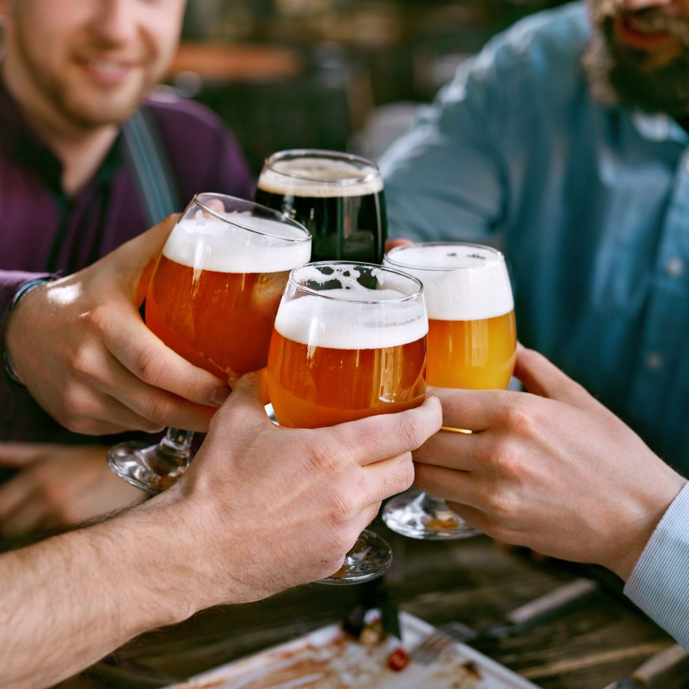 A person drinking a glass of beer, highlighting the risks of alcohol consumption for liver health.