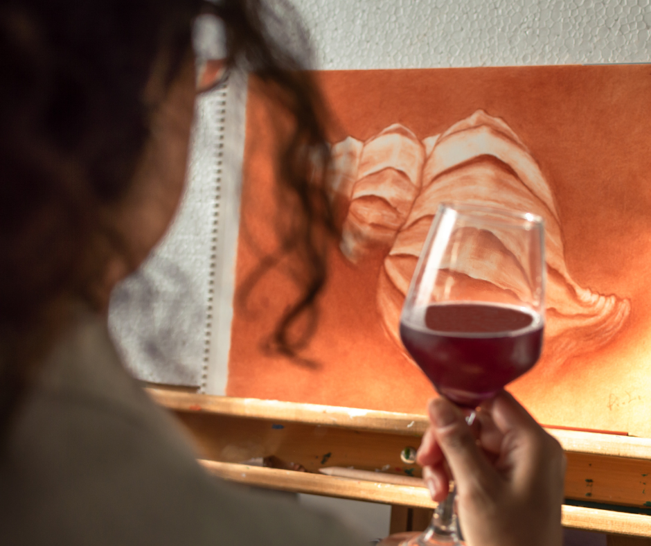 A person holding a glass of alcohol while looking at a bottle, representing the struggle of how to safely stop drinking alcohol at home