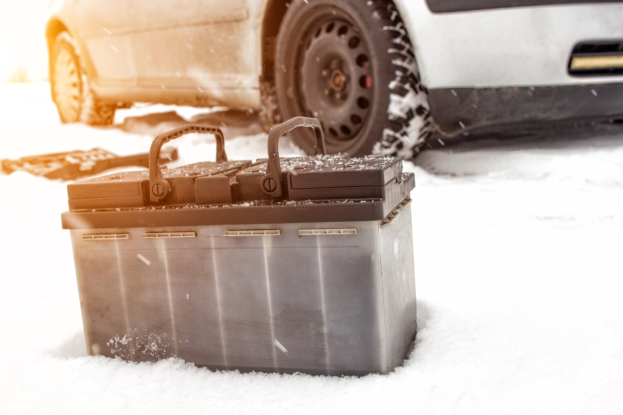 Car's battery on the ground, snow on background