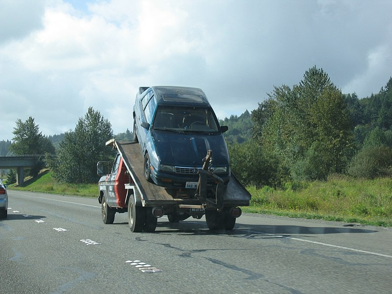 A tow truck removing a junk car