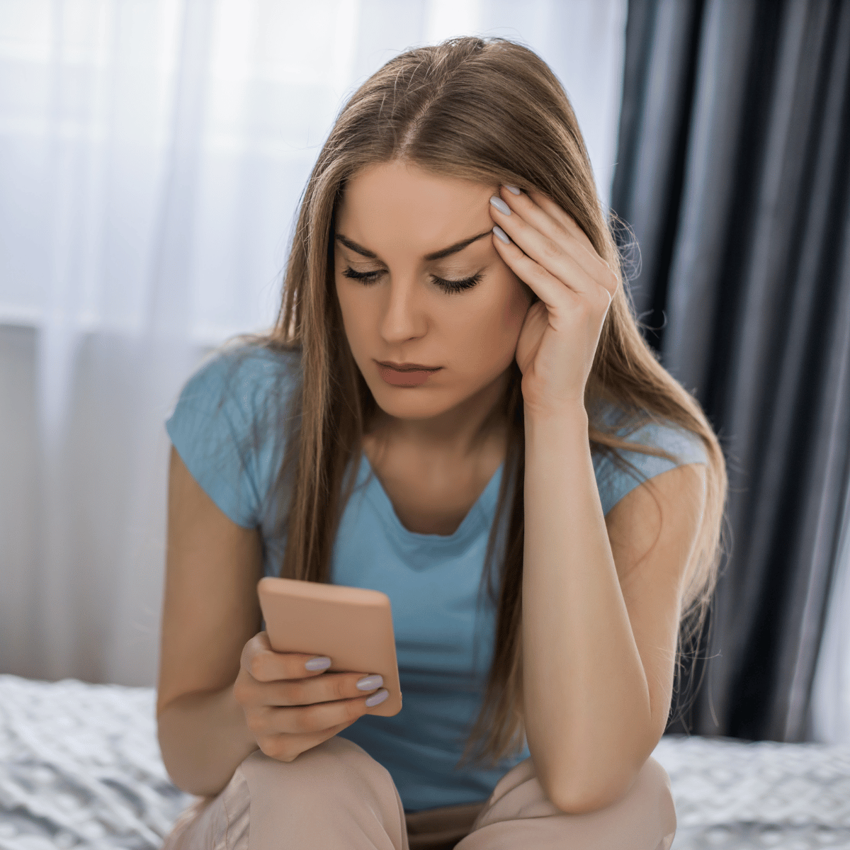 Woman looking at phone - Featured In: How To Stop Overthinking After Being Cheated On