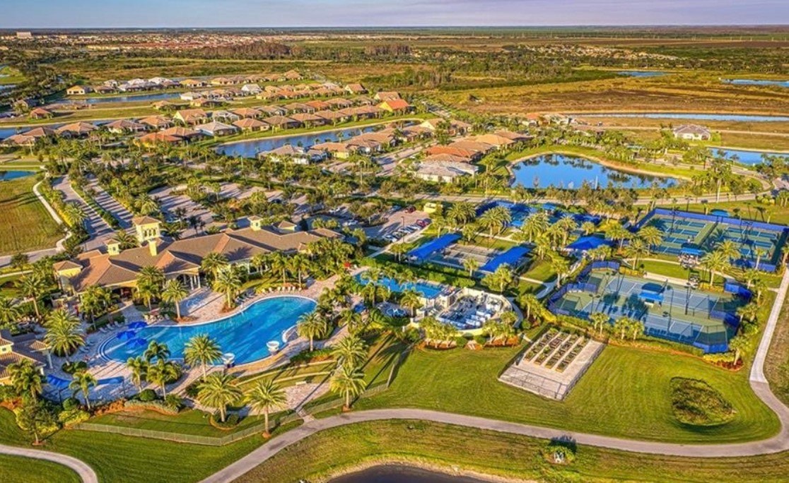 The image depicts a resort-style pool area surrounded by lush palm trees, featuring modern amenities such as comfortable lounge chairs and a spacious deck. This serene backdrop invites relaxation and leisure, perfectly complementing the luxurious lifestyle offered by the nearby Ave Maria community and its championship golf courses.