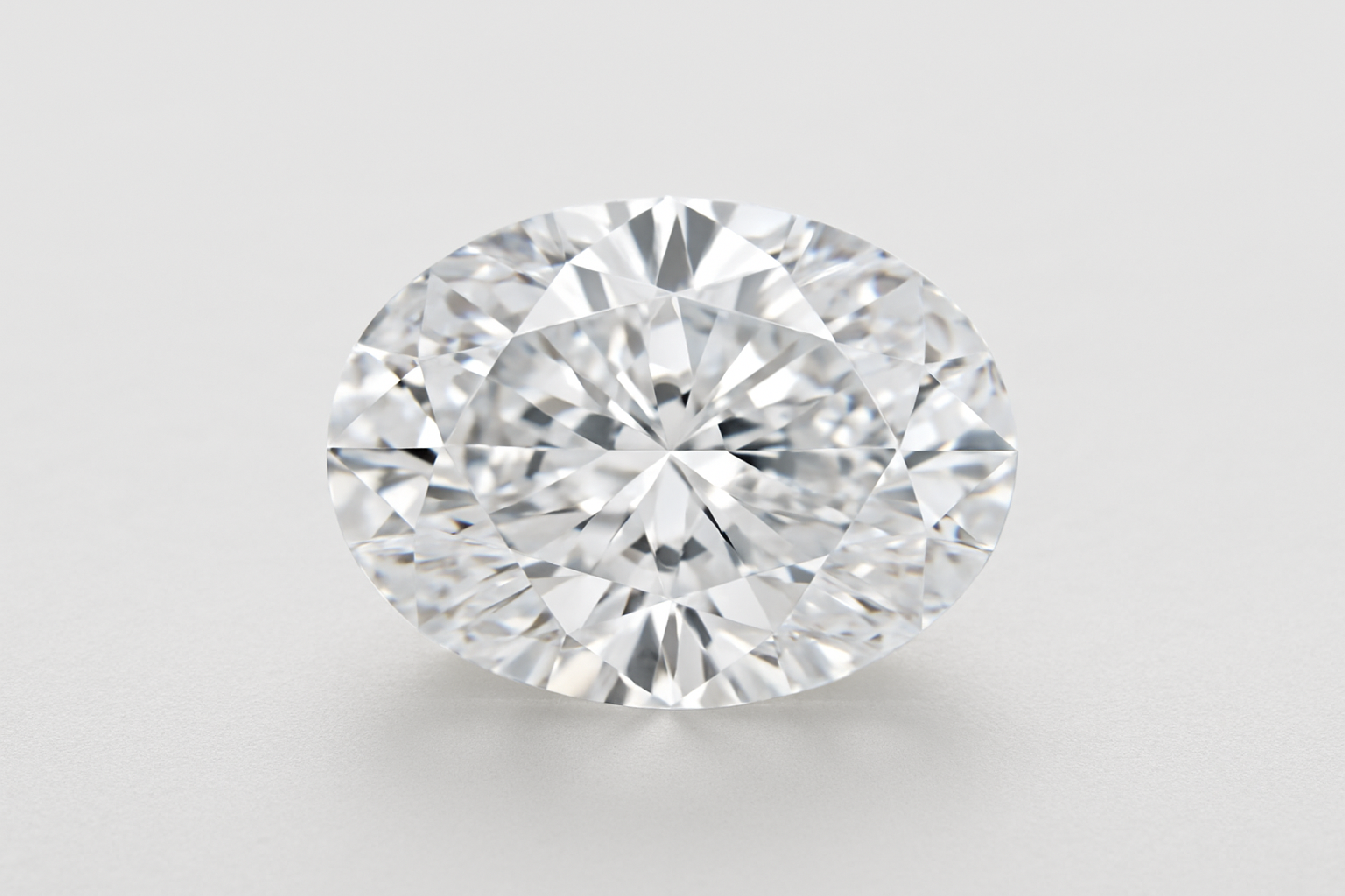 Ovalo formos deimantas ant šviesaus fono, ryškiai atsispindintis šviesoje, matomos visos briaunos ir spindesys
