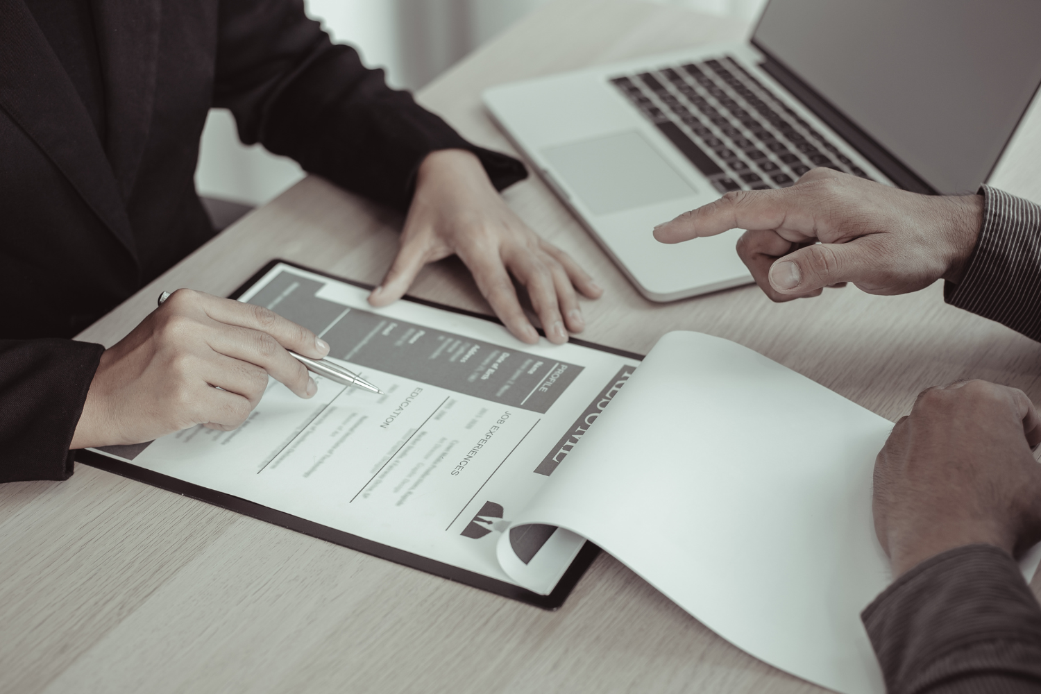 Two business professional checking documents.