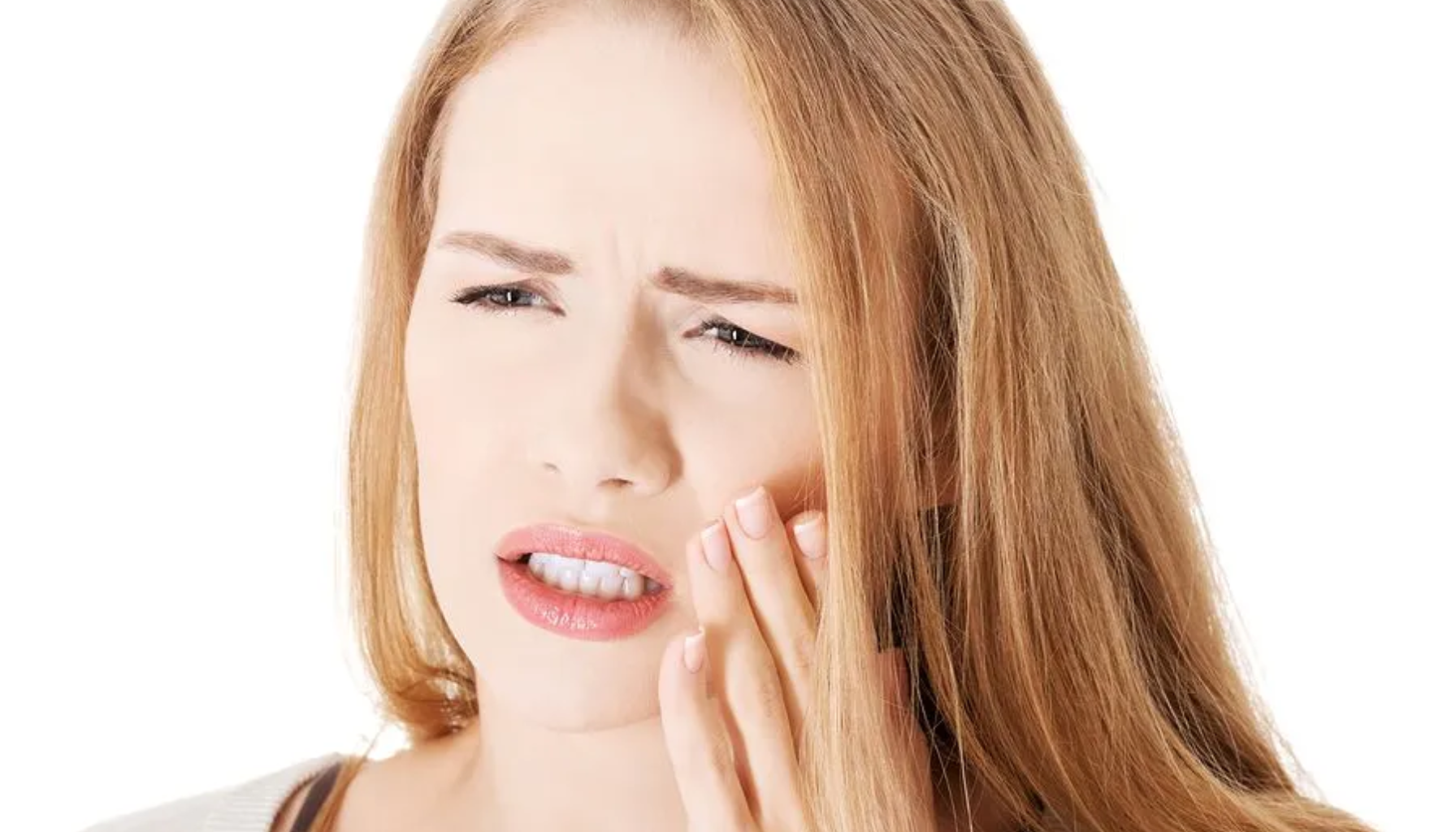 Tannsykdom tegnene du må oppdage før det er for sent 9 Kvinne som holder hånden mot kinnet og viser tydelige tegn på tann eller kjevesmerter.