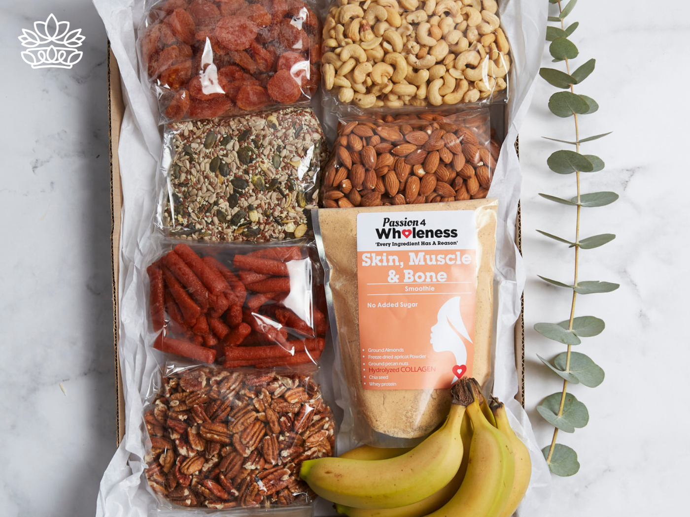 A selection of assorted snacks, including nuts, dried fruit, granola, bananas, and a smoothie mix, beautifully arranged in a gift box alongside eucalyptus leaves. Fabulous Flowers and Gifts. Gift Boxes for Boyfriend. Delivered with Heart.