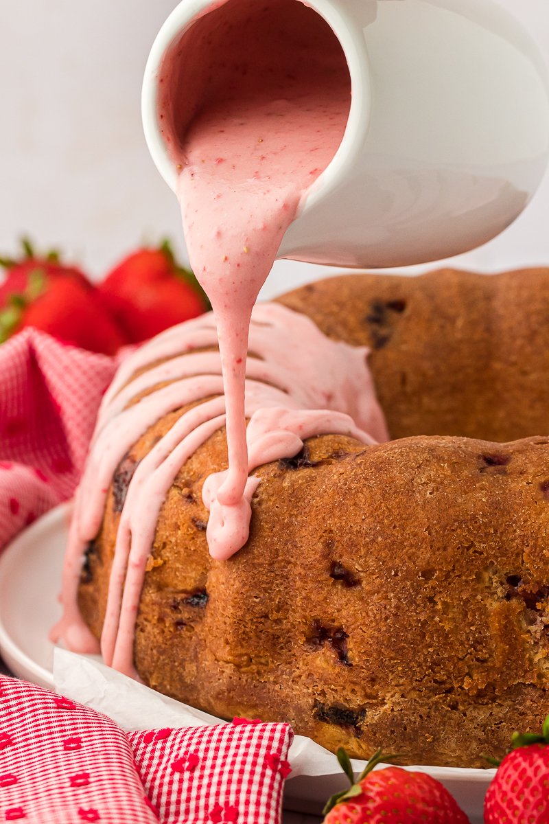 strawberry glaze being poured over strawberry pound cake