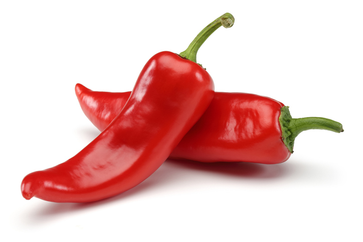 An image of two red chili peppers on a white background. 
