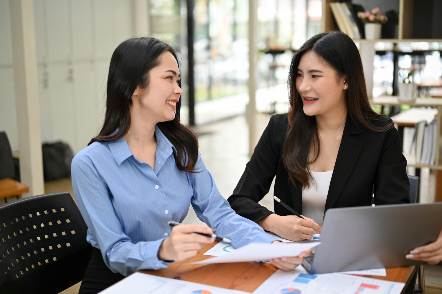 Two Filipino professionals having a respectful conversation in an office setting.