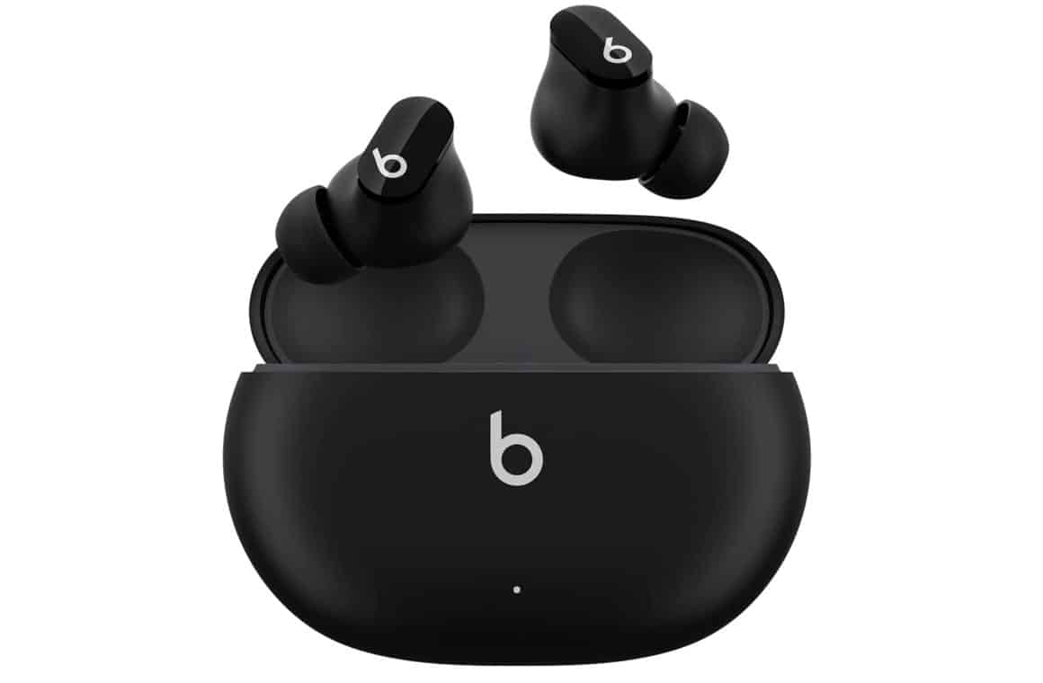 Black Beats Studio Buds earbuds in their charging case, with the lid open and the earbuds positioned inside. The case has a matte black finish and a LED light on the front indicating the charging status of the earbuds.