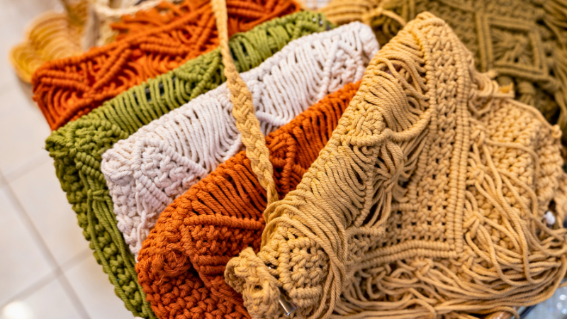 Colorful macrame jute bags on display in a store