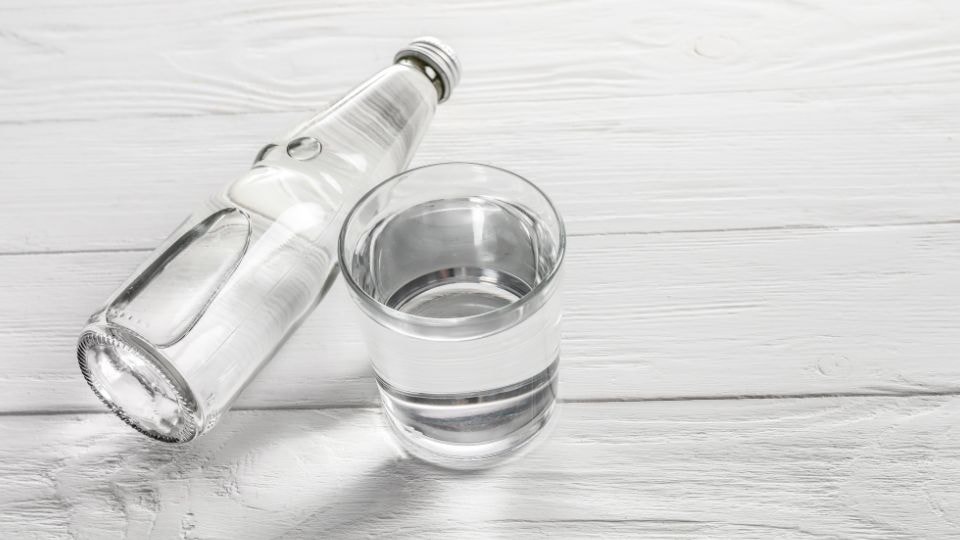 Woda alkaliczna butelkowana i szklanka z roztworem zasadowym wody z jonizatora