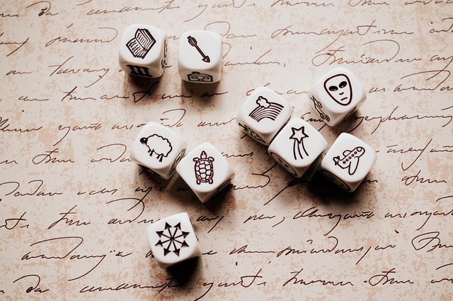 A collection of dice with symbols on a piece of poetry.