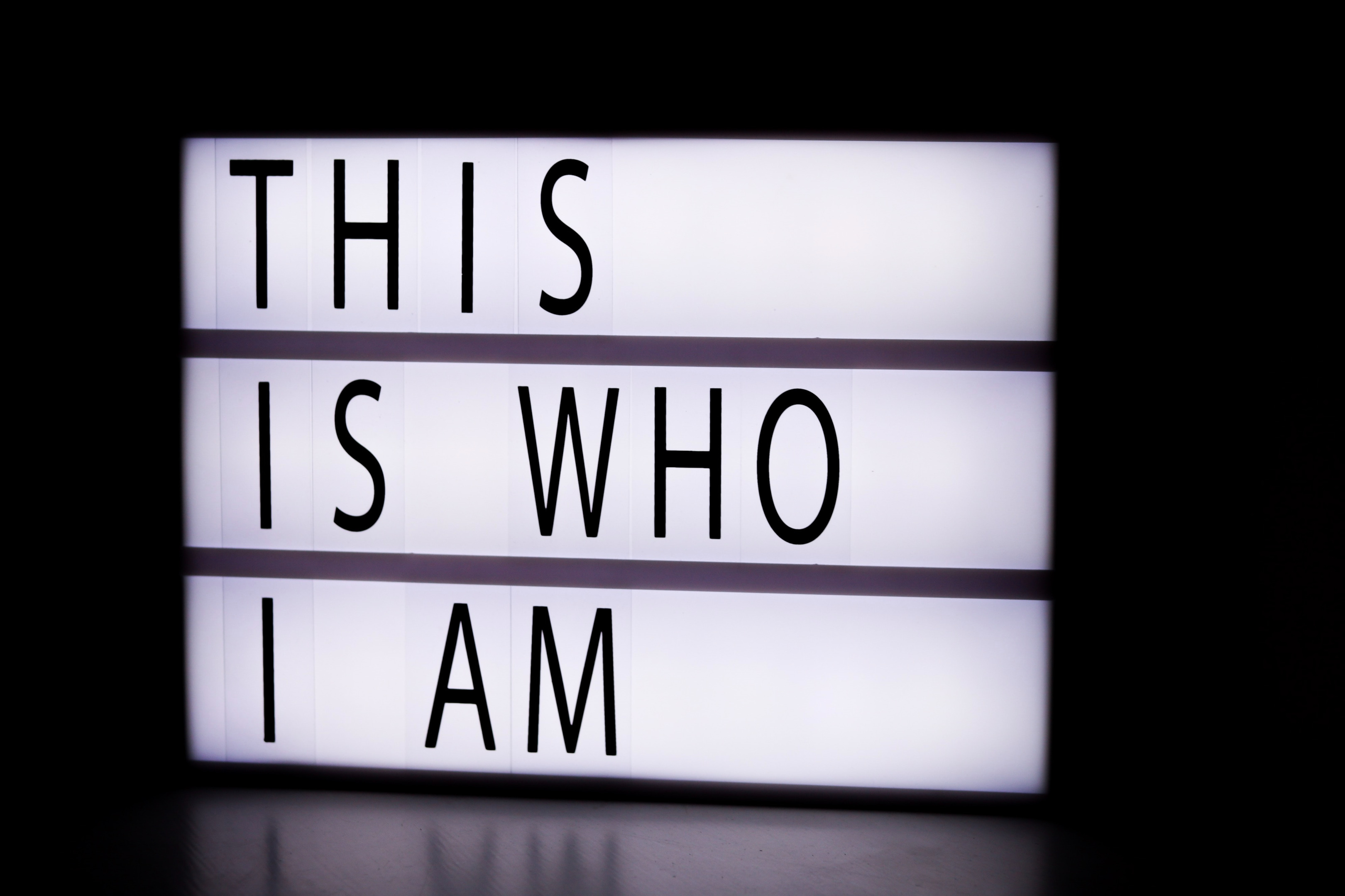 a lit up table sign that reads "This is who I am". 
