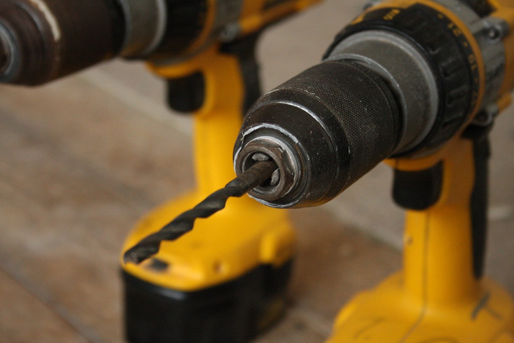 Близък план на свредло, поставено на жълта бормашина