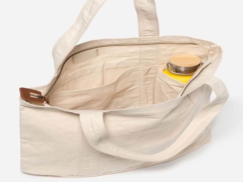 Canvas tote bag with a zipper and pockets.