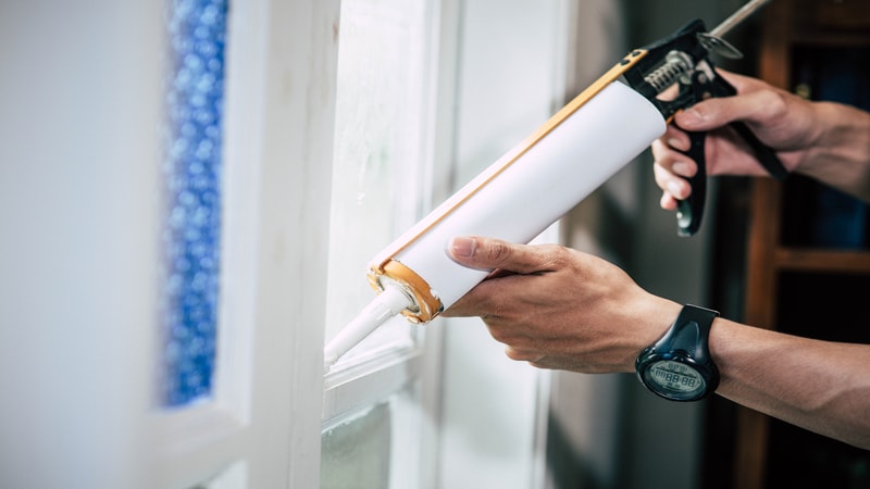 Sealing gaps around windows with silicone sealant