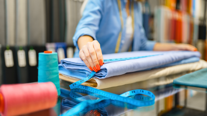 A person is cutting cupro fabric on a sewing machine