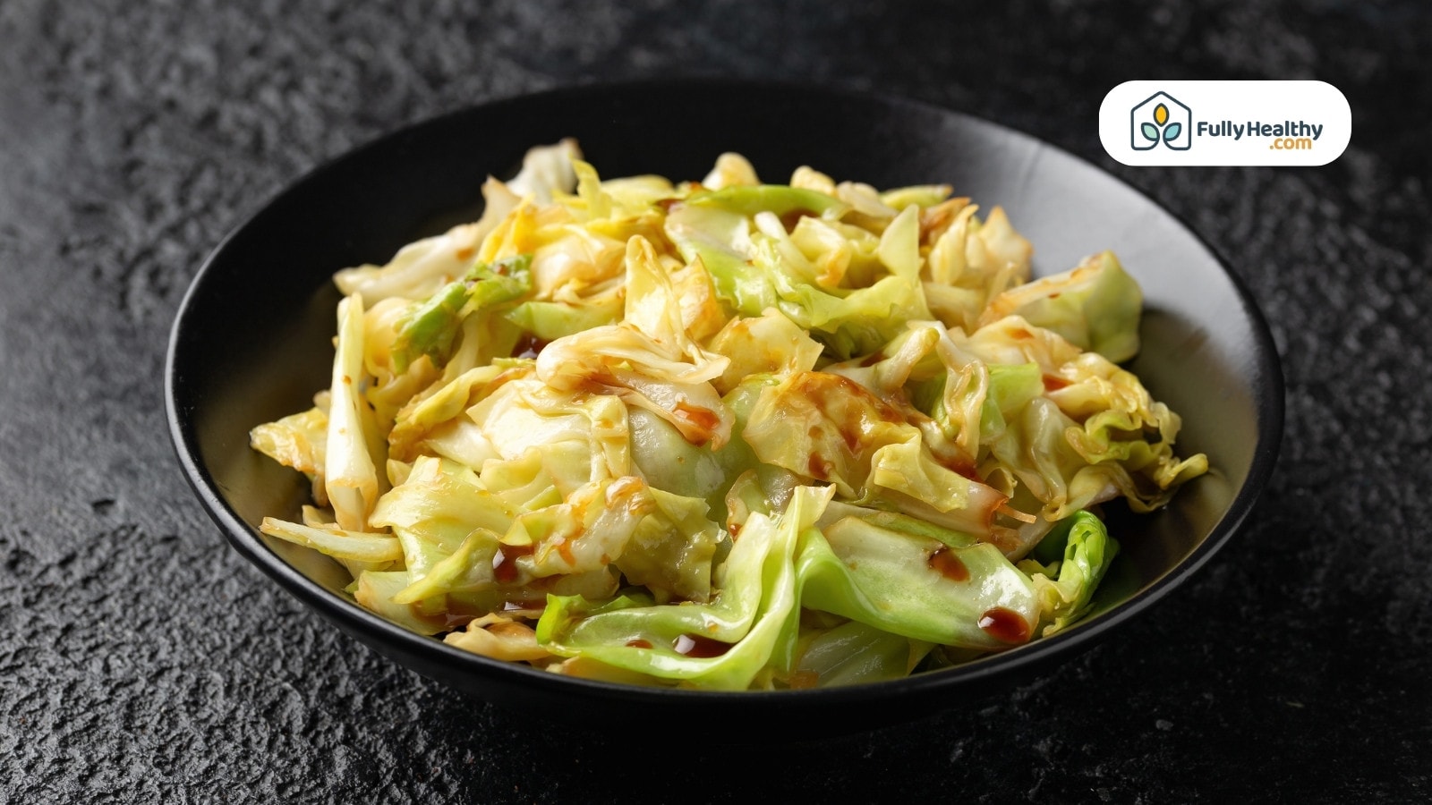 Stir fried cabbage with sauce served in black ceramic bowl