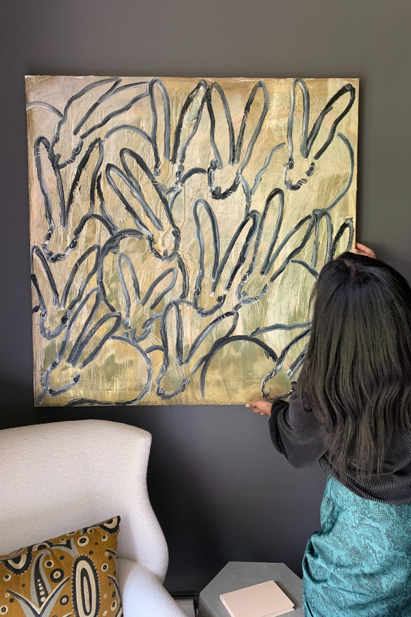 a designer repositions a painting of bunnies