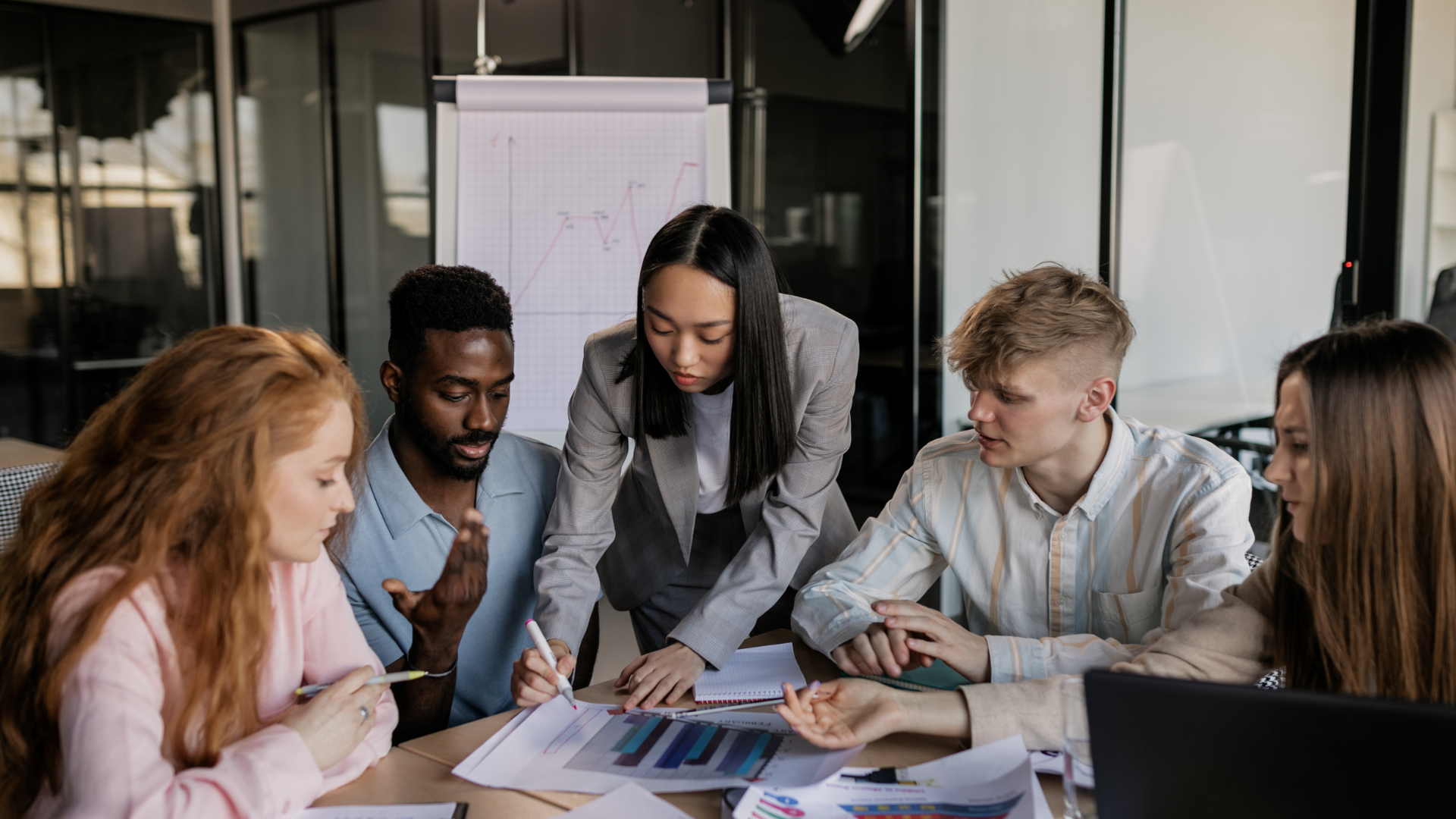 group of employees sitting around and looking at charts