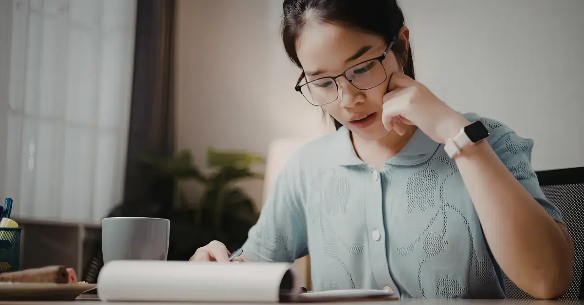 Woman reviewing a CP14 notice letter from the IRS at her home desk.
