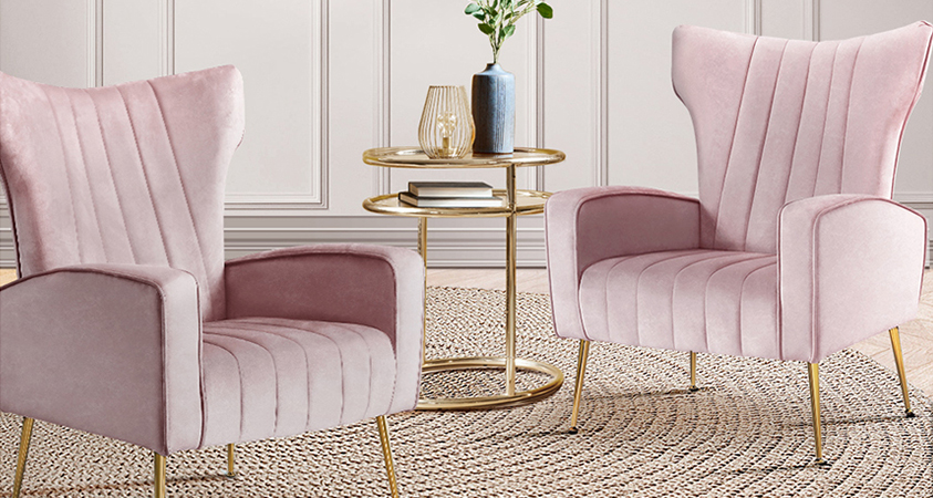 Two Artiss pink Kate armchairs set in a beige living room on a woven sisal rug, next to a gold and glass round coffee table.