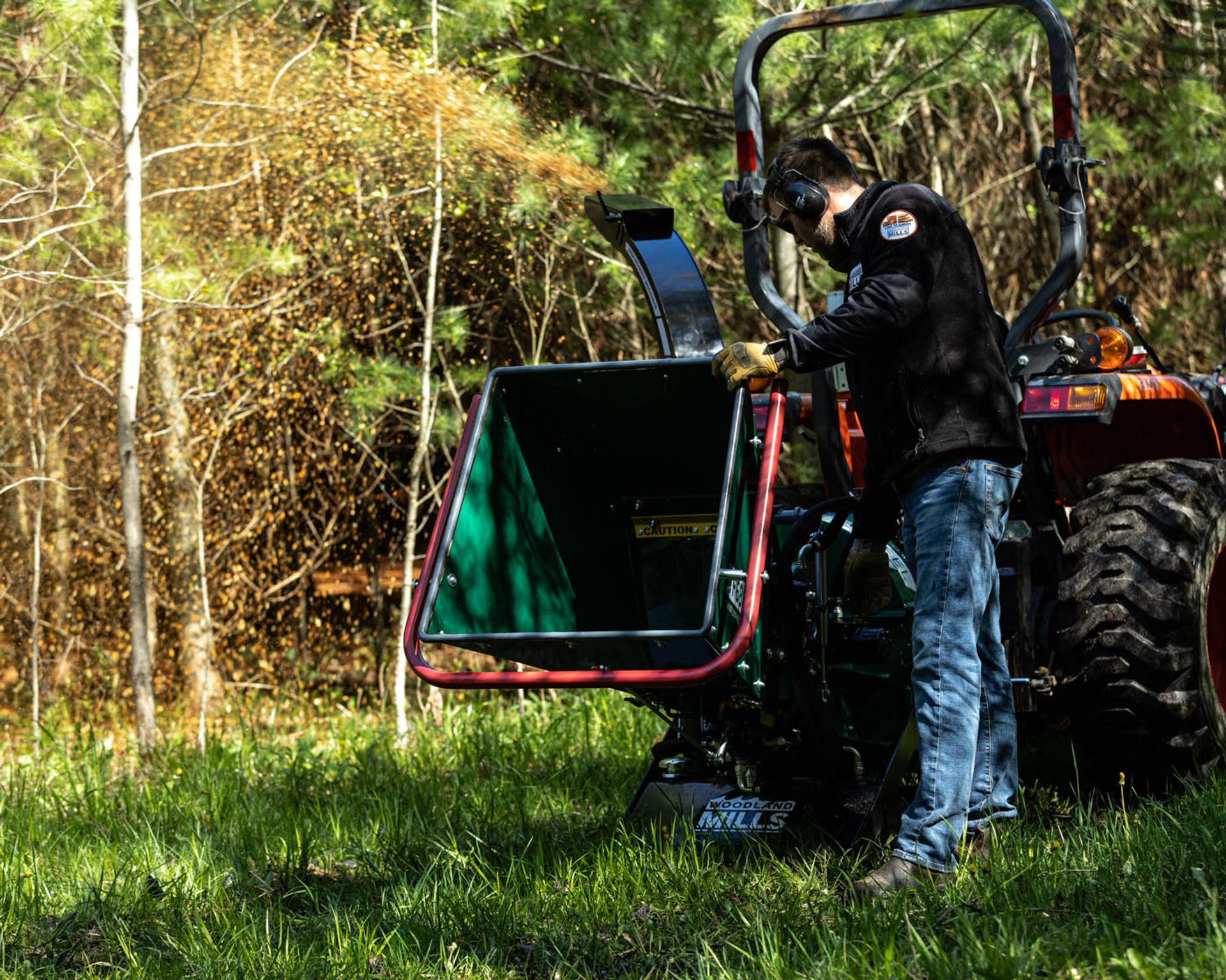 A man standing beside a Woodland Mills TF68 PRO Wood Chipper.