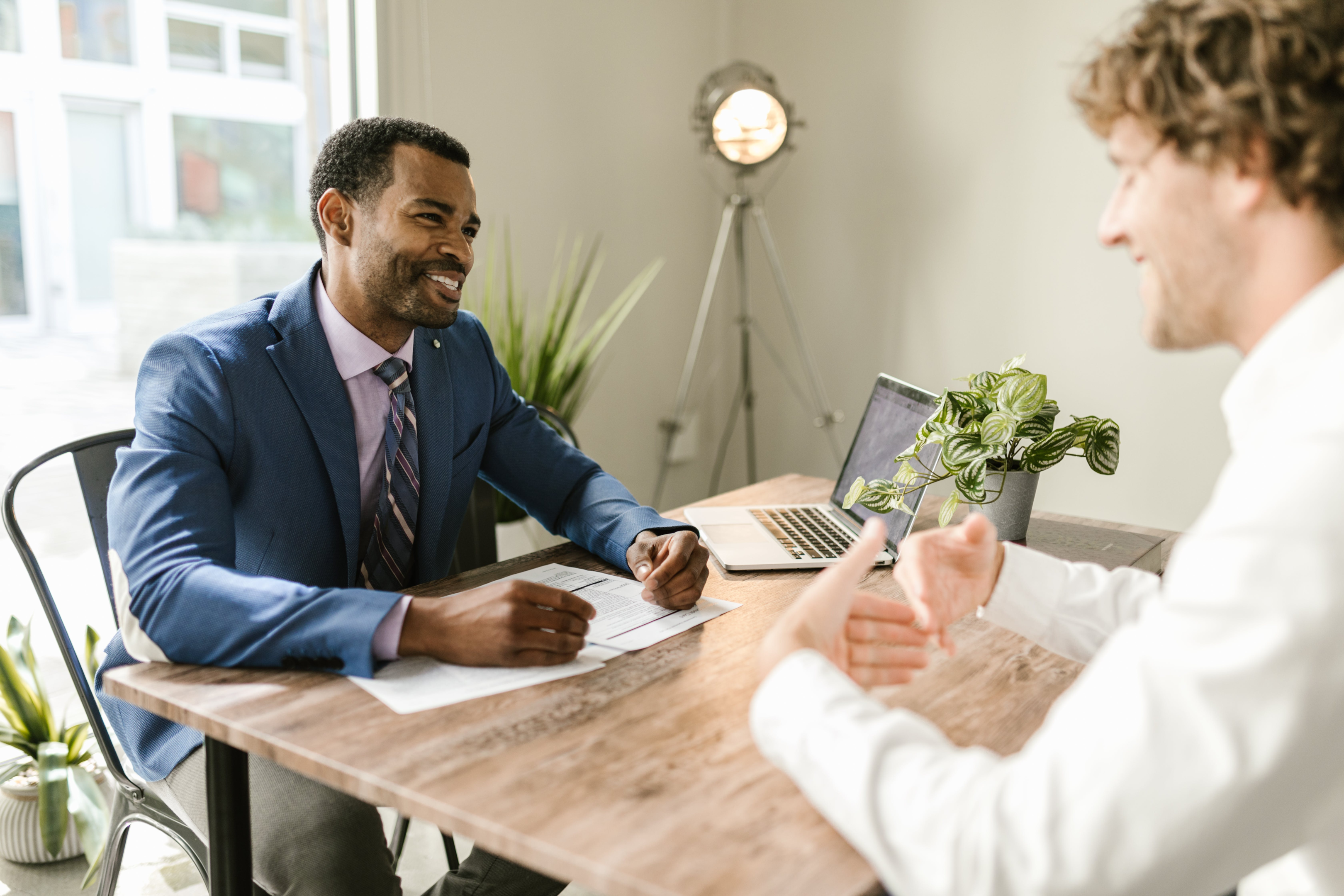 Man Sitting Across Table From Someone He Is Interviewing