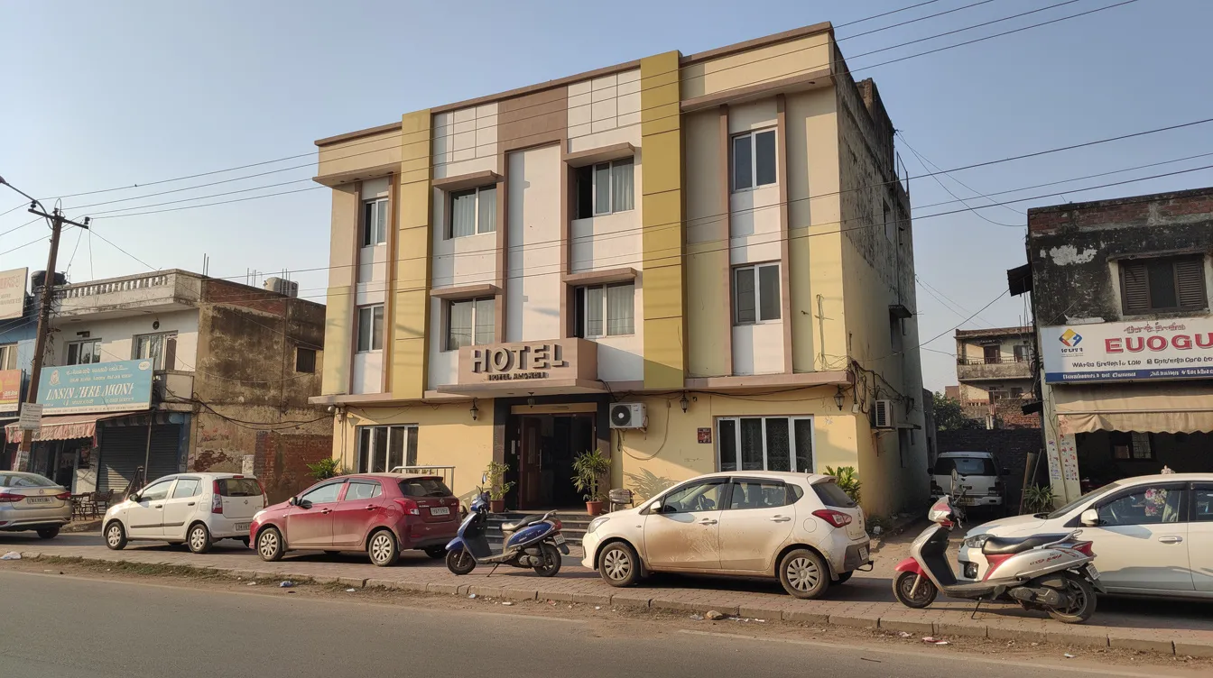 4134b540 2df4 4dff a13f 6afd19642349 The image depicts the exterior of a small budget hotel in an Indian tier-2 city, featuring parked cars and a clear blue sky overhead. This scene highlights the potential for market demand and financial viability in the hospitality industry, relevant for a comprehensive hotel feasibility study.