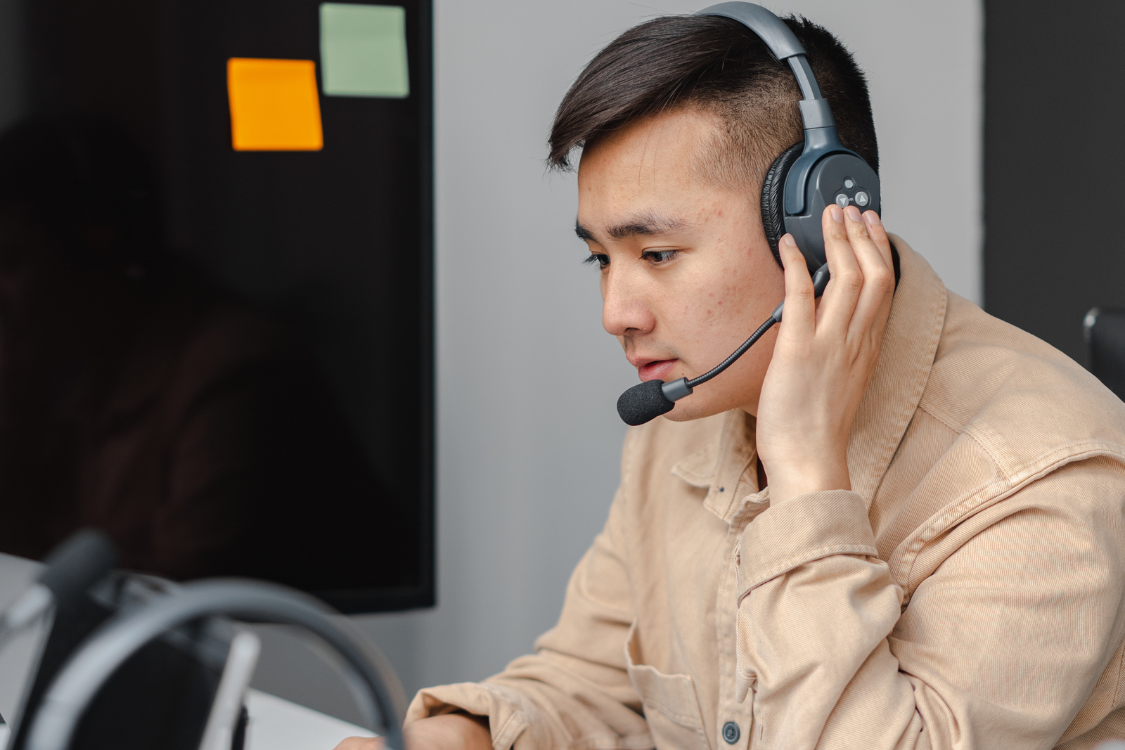 Focused Filipino virtual assistant working with a headset in a remote setup