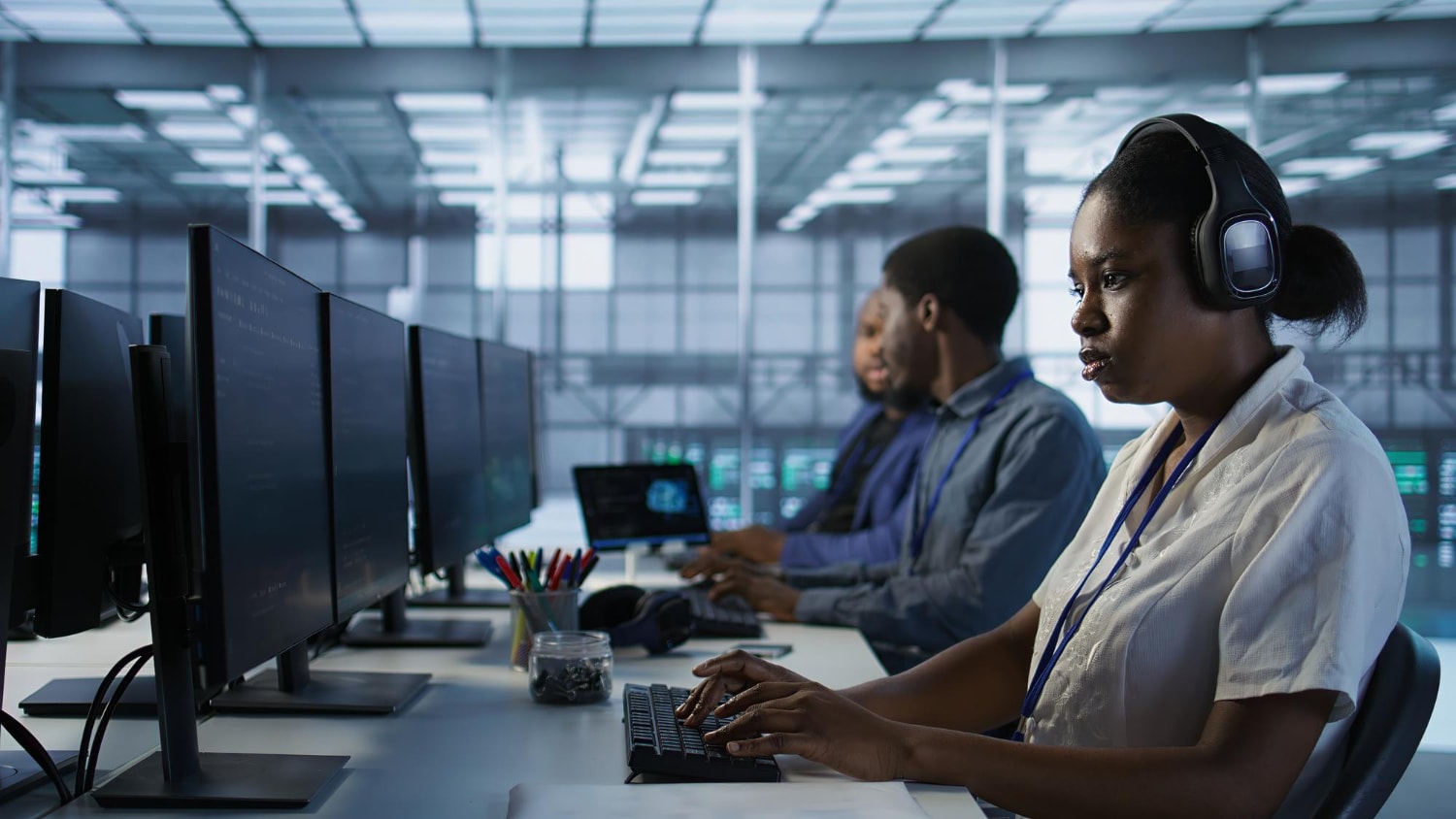A group of professionals working at a call center, focused on their monitors while wearing headsets. The image highlights VoIP, business phone systems, and customer communication tools.
