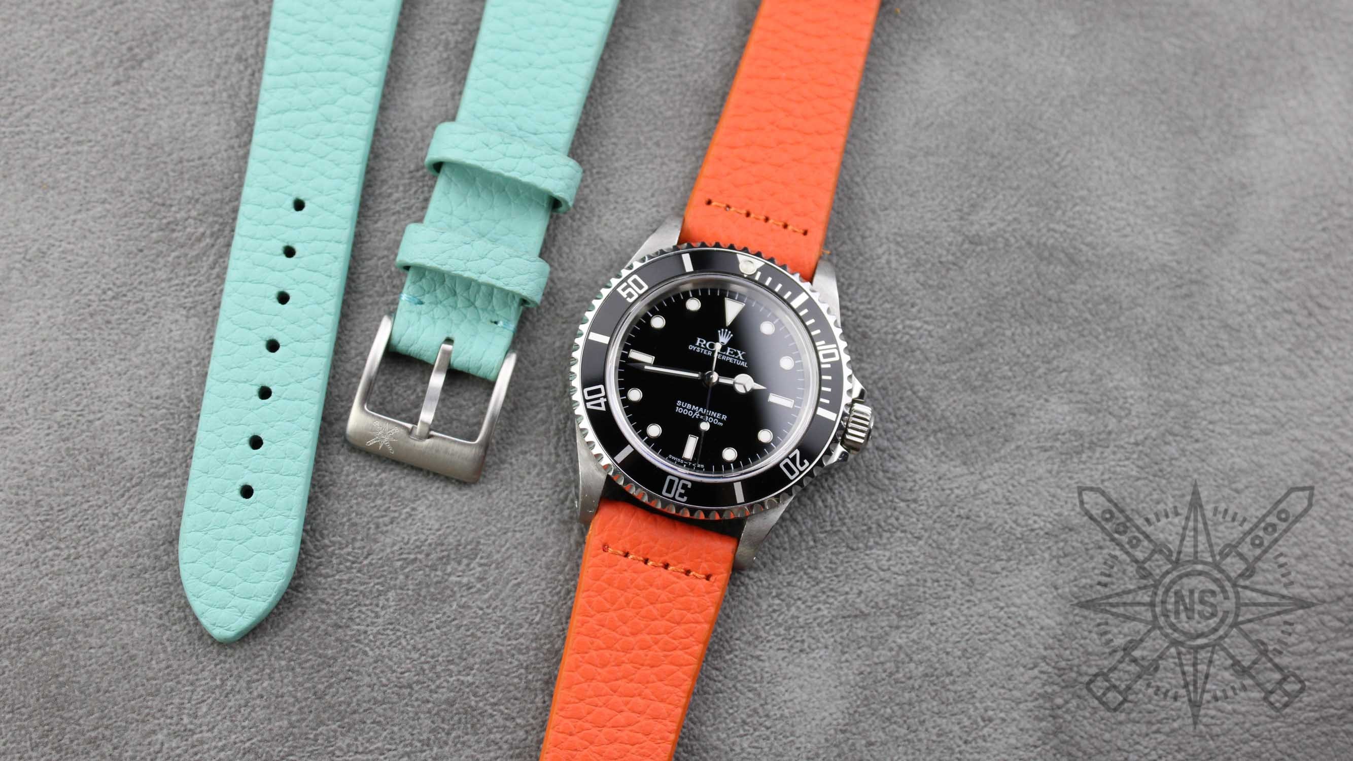 The Heritage Pebble Orange Watch Band presented on a wrist.
