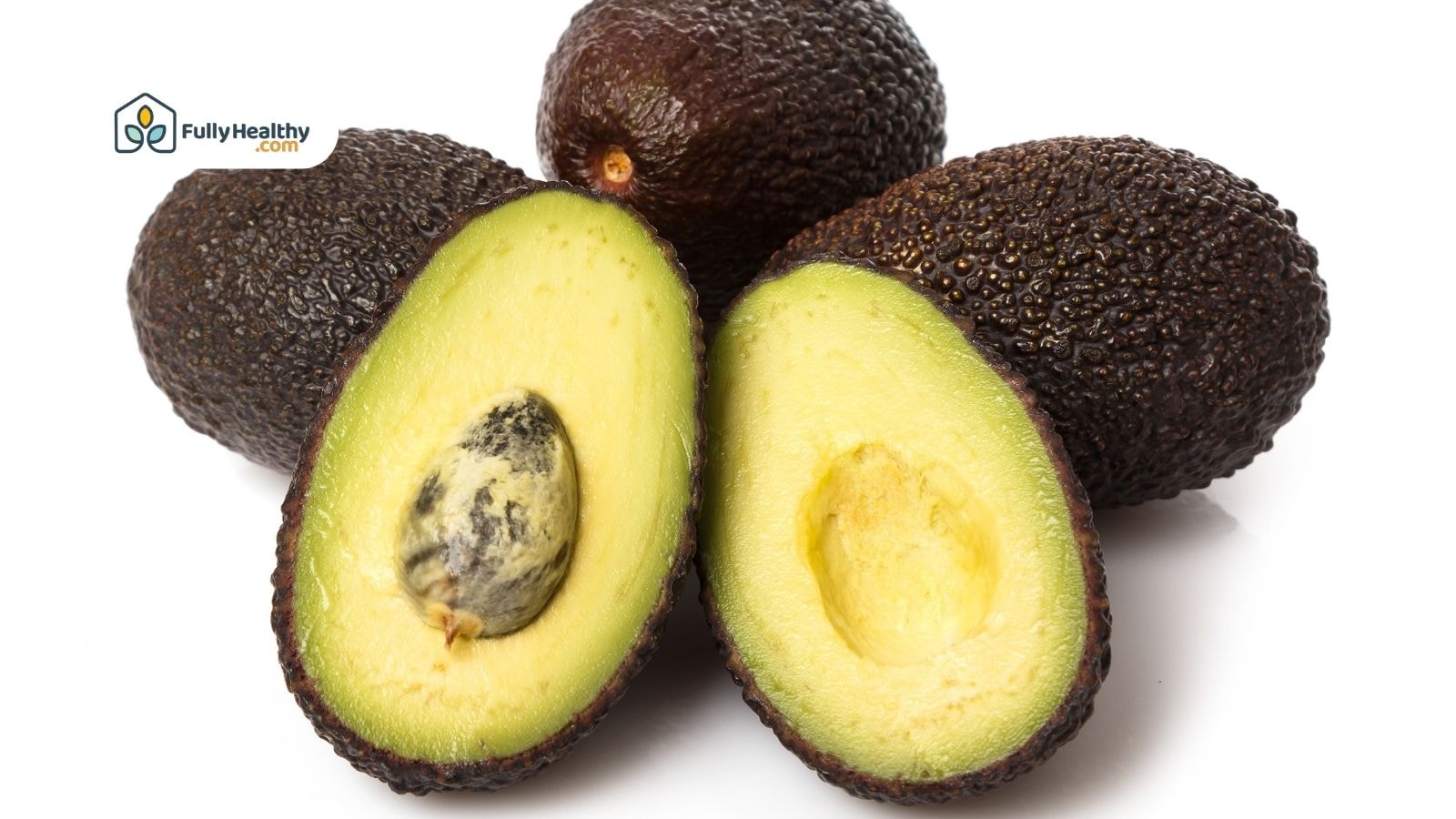 Ripe Hass avocados with one halved showing pit