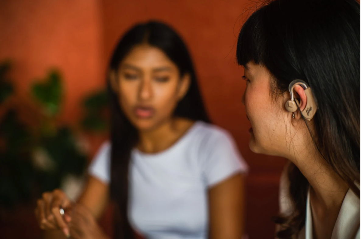 two females having a conversation, one with a hearing impairment