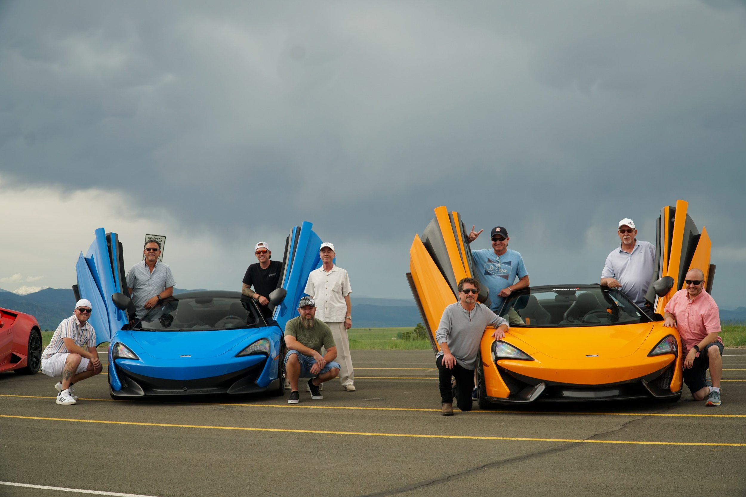 Two groups posed with Oxotic supercars 