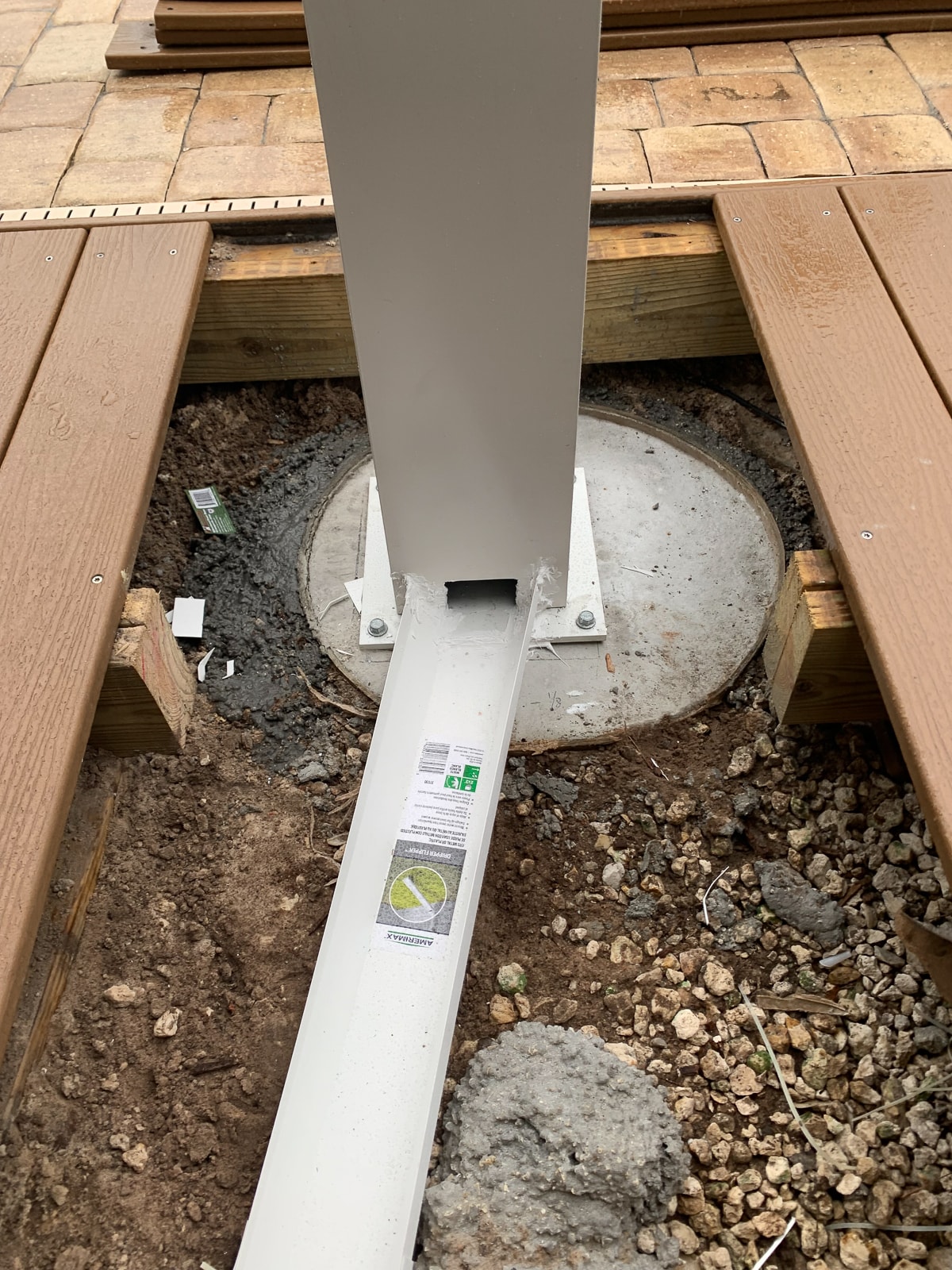 materials connected to a pier footer rests underneath a deck/porch area  ideal for building a pergola.