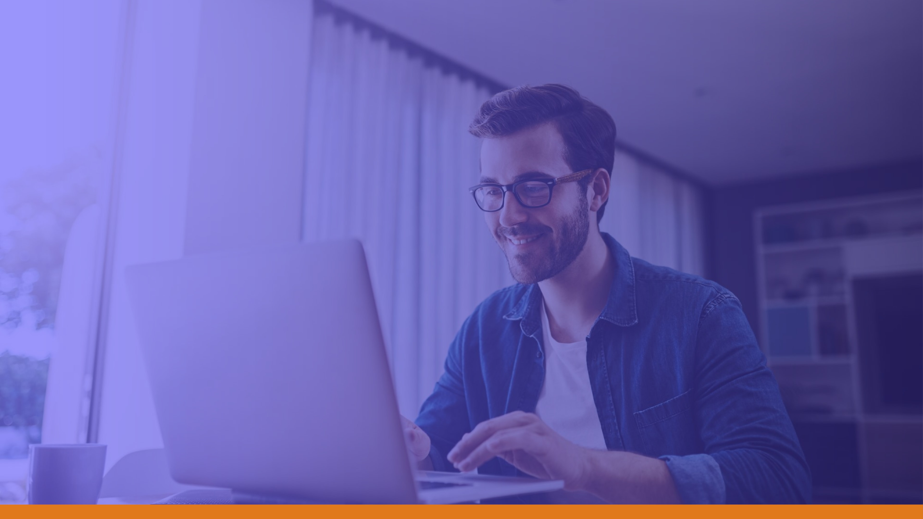 Smiling man using a laptop at home, representing how integrated public alert systems ensure consistent communication through an emergency notification system, even remotely.