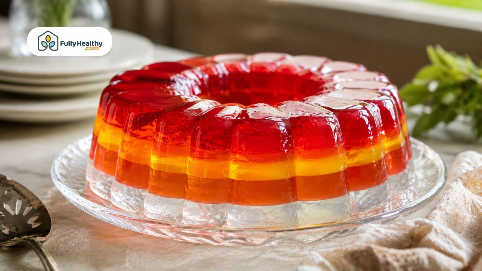 Layered red and orange gelatin ring dessert served on a glass platter.