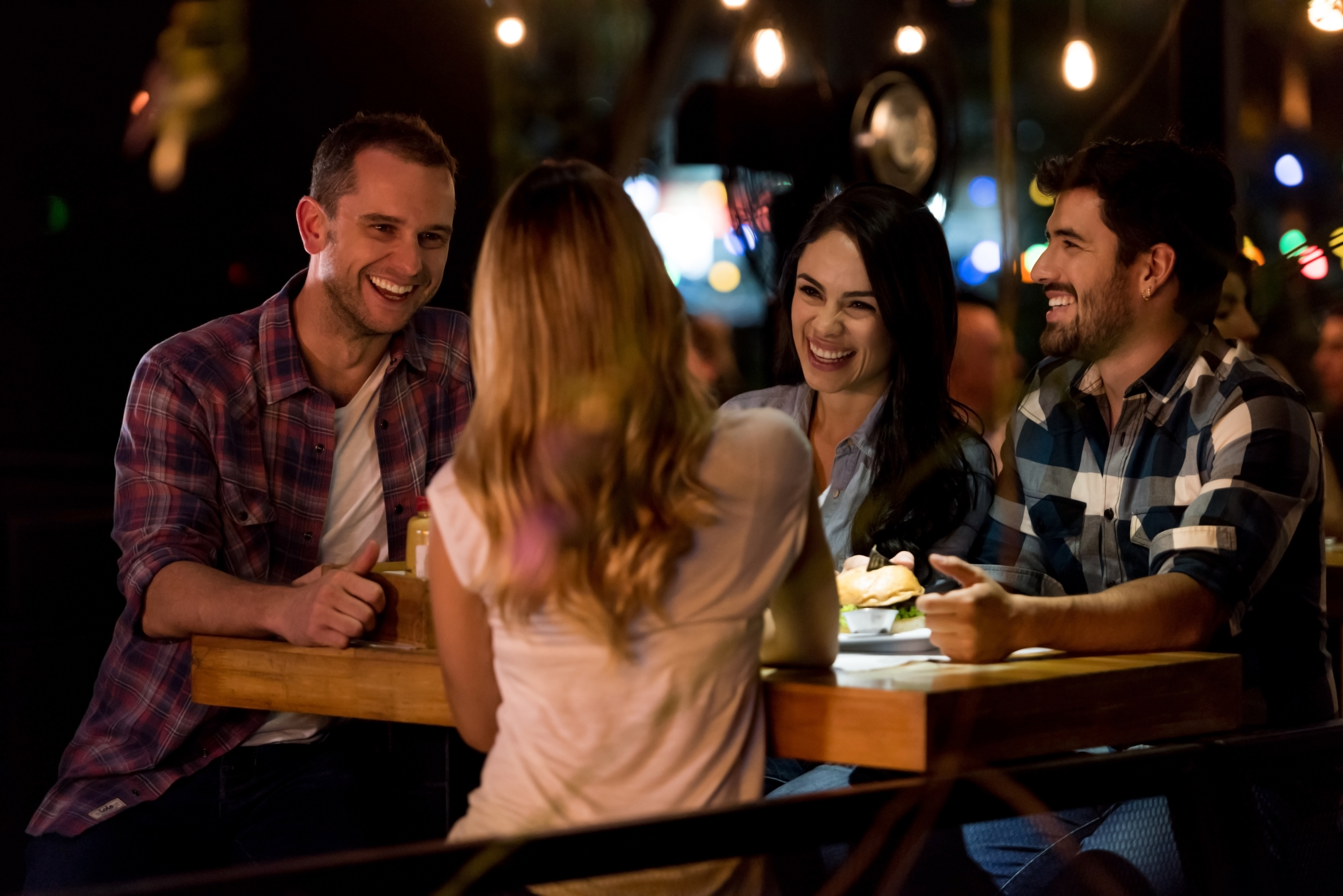 Happy group of friends eating at a restaurant 