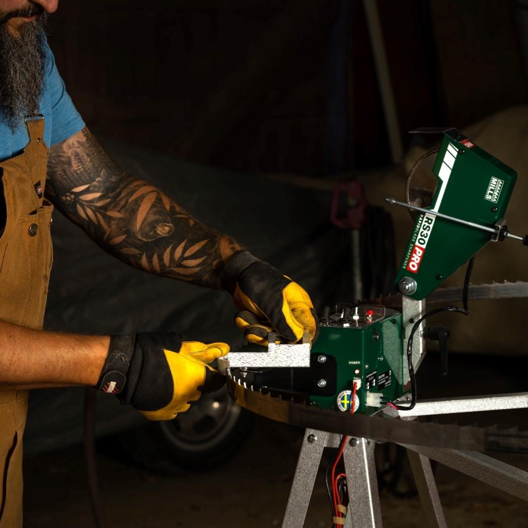 A sawyer using an RS30 PRO Bandsaw Blade Sharpener to sharpen their bandsaw's sawmill blades. 