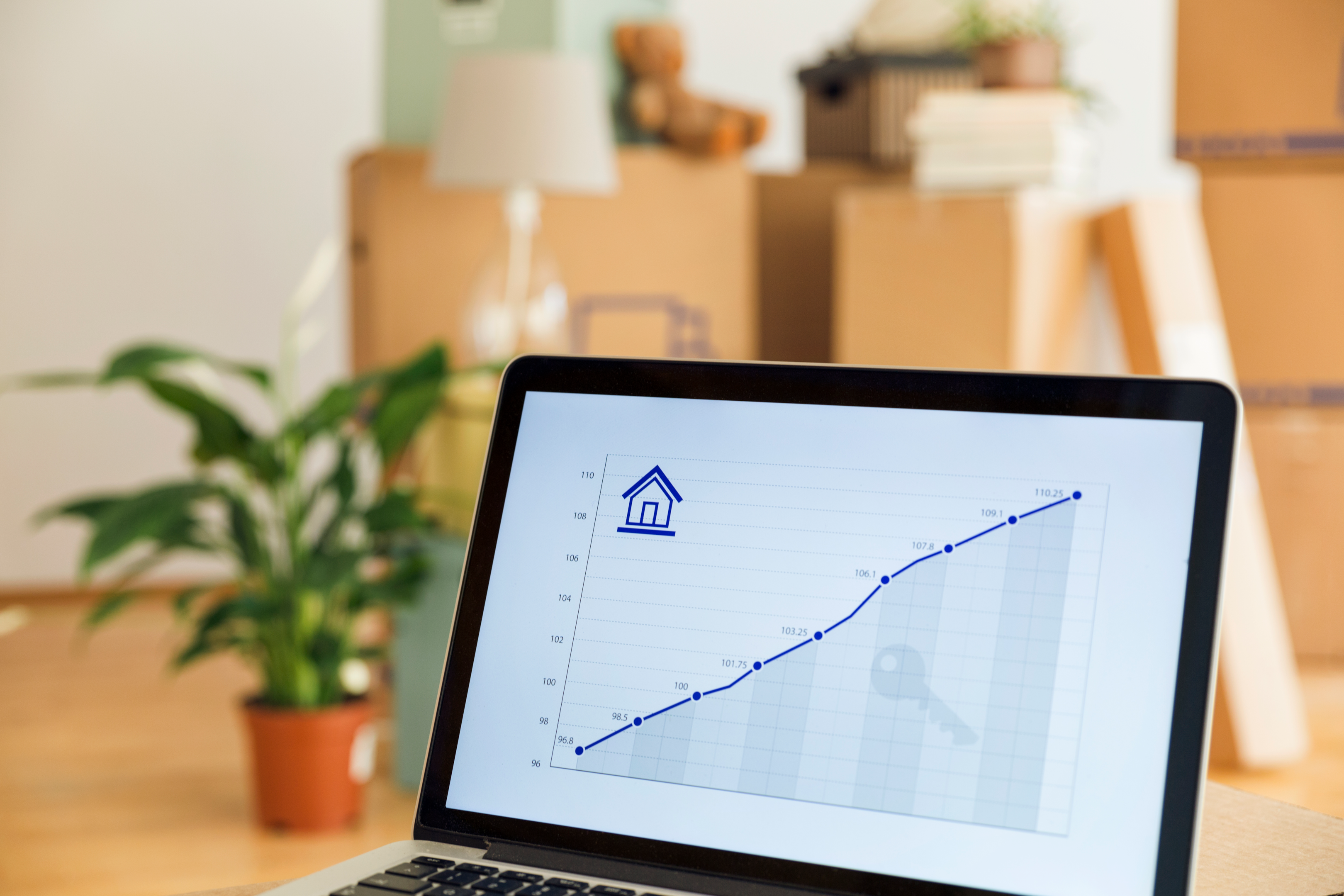Steigender Graph auf Computer zeigt Anstieg der Preise von Immobilien. Immobilien werden teurer.