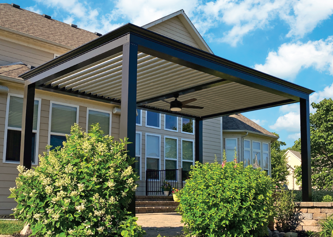 A louvered roof luxury pergola with accessory beam and fan, installed over a patio.