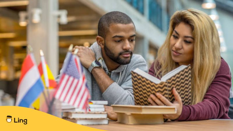 Multi ethnic university adult student couple learning languages together in a study hall