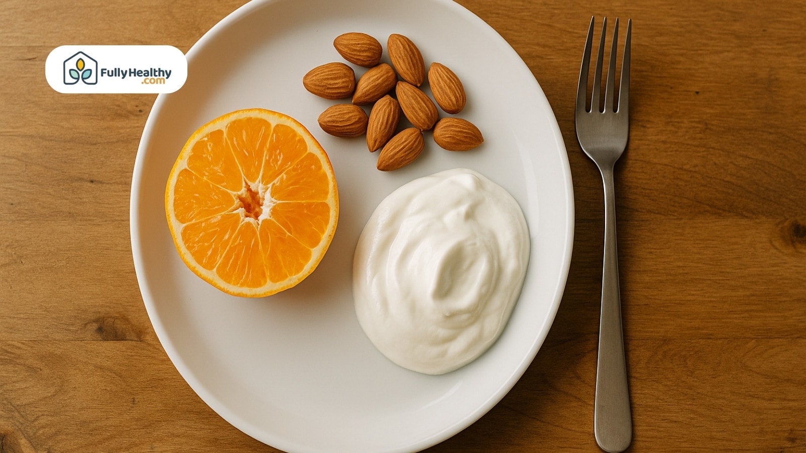 Plate with half orange almonds and yogurt beside a fork on wooden table