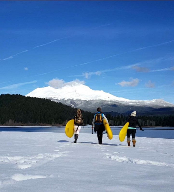 inflatable paddle boards being carried in snow