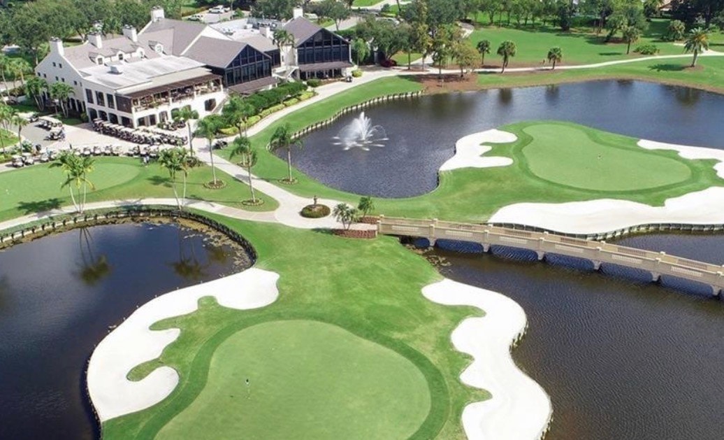 An aerial view showcases the Fiddlesticks Country Club in Fort Myers, FL, featuring lush golf courses and a spacious clubhouse, all surrounded by luxury homes. This welcoming community offers world-class amenities, including tennis courts and a vibrant atmosphere for new members to connect and enjoy friendships on the fairways.