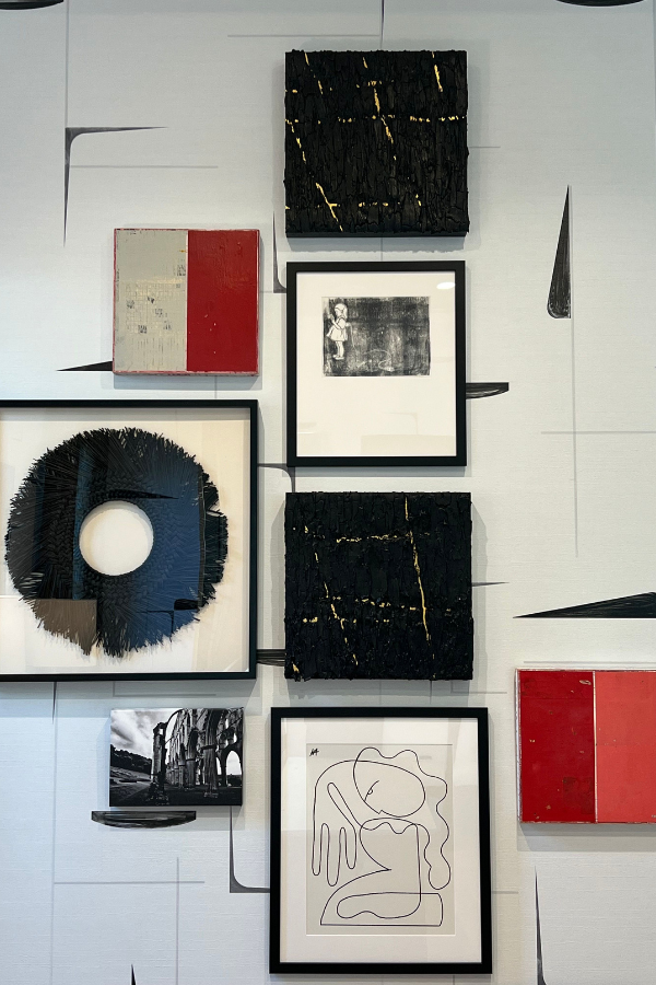 a gallery wall with white, black, and red pieces