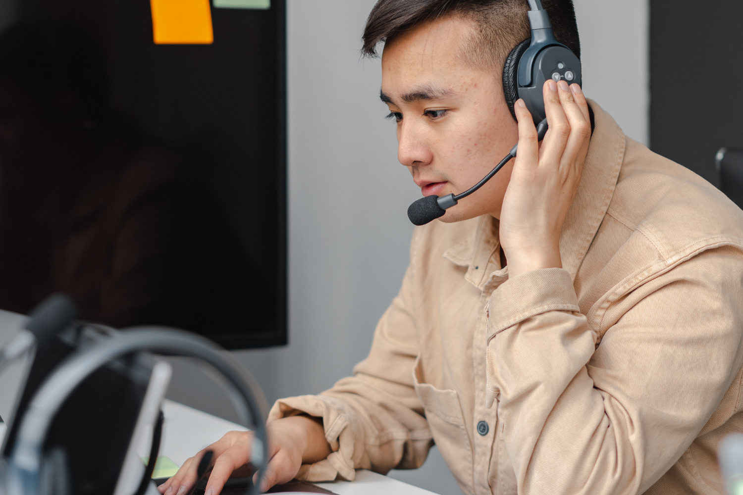 Filipino VA speaking through headphones.
